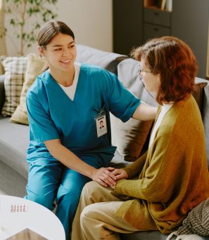Smiling Nurse Comforting Patient in Home Setting